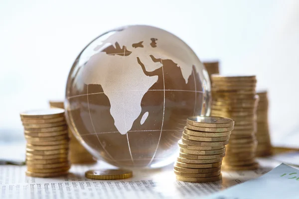Stacked coins and glass globe — Stock Photo, Image