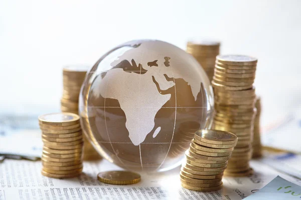 Stacked coins and glass globe — Stock Photo, Image