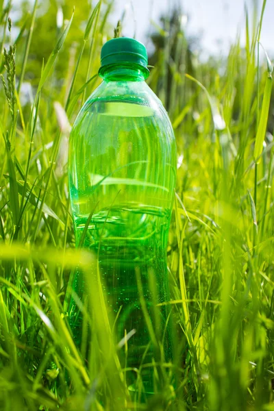 Água na garrafa na grama — Fotografia de Stock