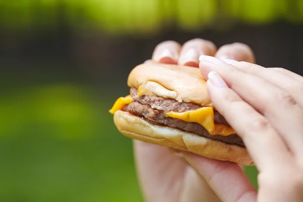 Žena jíst hamburger — Stock fotografie