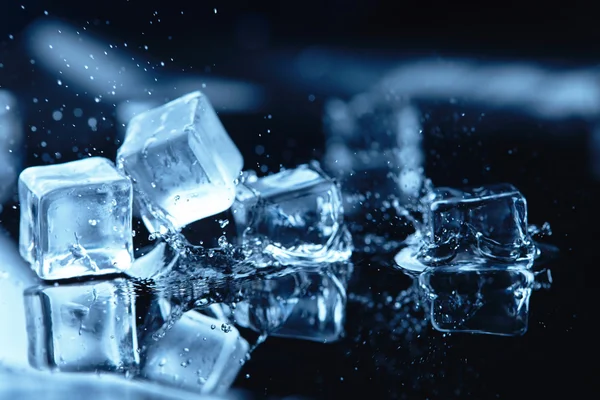 Cubitos de hielo en agua azul — Foto de Stock
