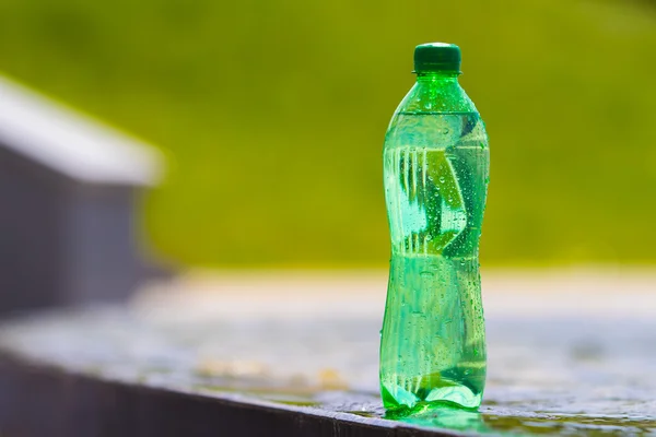 Zielone Butelki Wodą Niewyraźne Tło — Zdjęcie stockowe