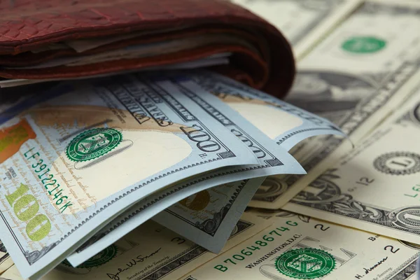 Бумажник с деньгами, обернутыми ремнем — стоковое фото