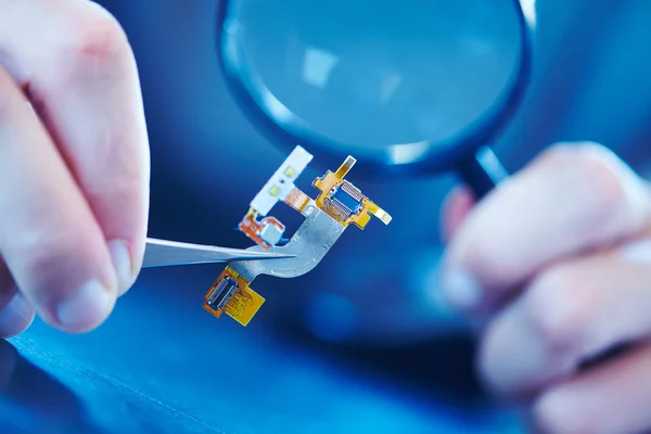 Man holding microchip with tweezers — Stock Photo, Image