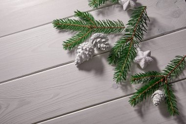 Noel ağacı dalları ve ahşap arka planda karlı süslemeler olan bir Noel kartı.