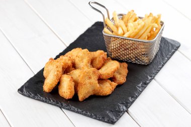 Kızarmış patates kızartması ve yanında tavuk parçaları, yakın görüş.