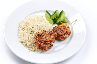 Beyaz tabakta pirinçli domuz kebabı, yakın görüş.