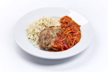 Beyaz tabakta pirinç ve sebzeli et, yakın görüş.