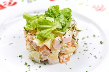 Beyaz tabakta Rus salatası, yakın görüş.