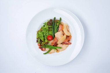 Beyaz tabakta sebzeli tavuk, yakın görüş. 