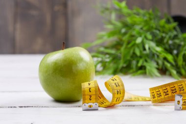 Ahşap zemin üzerinde şerit olan elma, yakın görünüm 