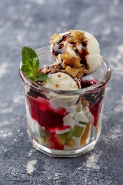 Gri arka planda taze meyve ve cam şerbetli dondurma, yakın görüş.