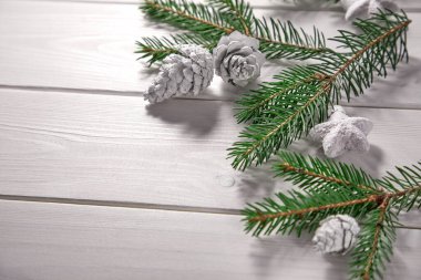 Çam kozalaklı Noel ağacı dalları ve ahşap arka planda dekoratif yıldızlar.