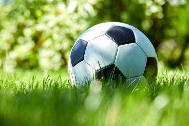 Güneşli bir günde yeşil çayır üzerinde futbol topu