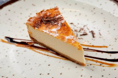 Beyaz tabakta çikolata soslu leziz peynirli kek, yakın görüş. 