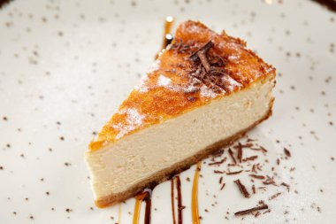 Beyaz tabakta çikolata soslu leziz peynirli kek, yakın görüş. 