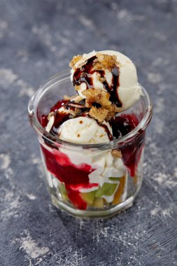 Gri arka planda taze meyve ve cam şerbetli dondurma, yakın görüş.