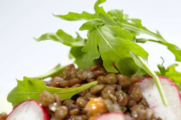 lentil salad with green lentil on white plate, close view