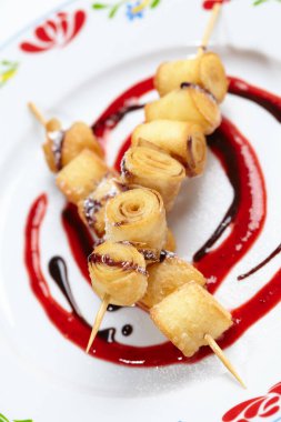 Beyaz tabakta soslu kızarmış tatlı rulo, yakın görüş. 