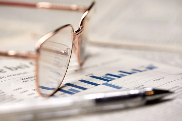 eyeglasses on newspaper pages, close view, business concept