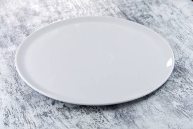 Ahşap zemin üzerinde boş beyaz tabak, yakın görünüm 