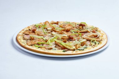 Beyaz tabakta etli ve mantarlı pizza, yakın görüş.