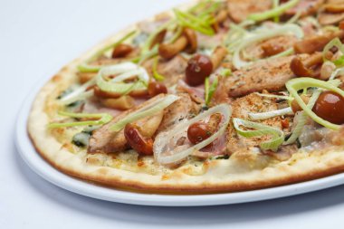 Beyaz tabakta etli ve mantarlı pizza, yakın görüş.