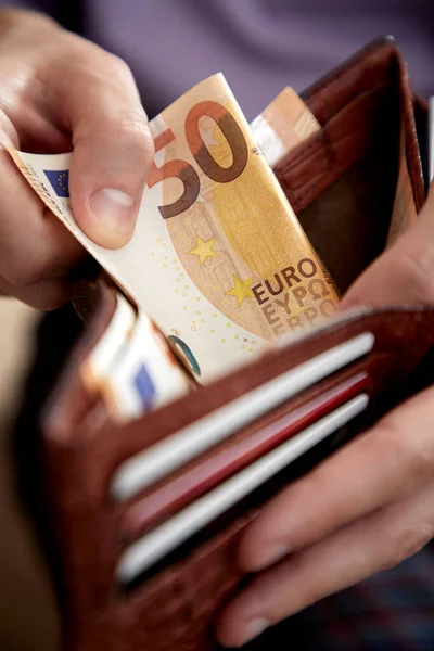 male hand putting banknote in purse, close view