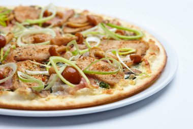 Beyaz tabakta etli ve mantarlı pizza, yakın görüş. 