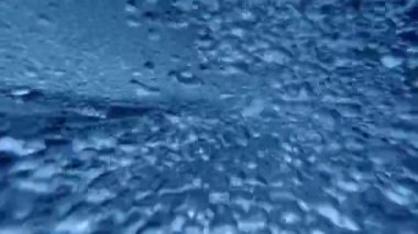Hava kabarcıklarıyla akan mavi suyun sualtı görüntüsü