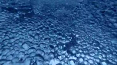 Hava kabarcıklarıyla akan mavi suyun sualtı görüntüsü