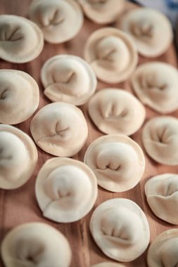 Ahşap kesim tahtasında süzme peynirli çiğ hamur köftesi, yakın görüş. 