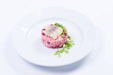 Beyaz tabakta ringa salatası, yakın görüş. 