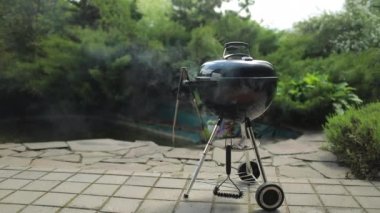 Yaz güneşli bir günde bahçede çaydanlık kömürü ızgarasının manzarasını kapat. 