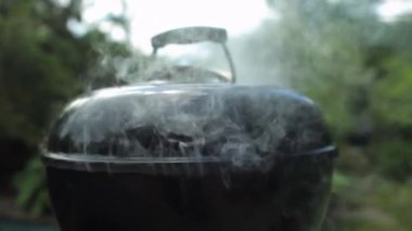 Yaz güneşli bir günde bahçede çaydanlık kömürü ızgarasının manzarasını kapat. 