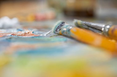 Renkli arkaplanda sanatçı boya fırçaları, yakın plan