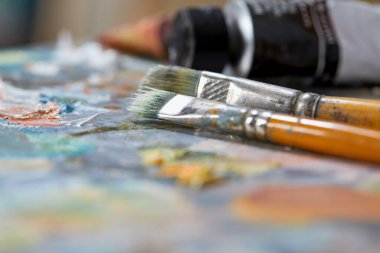 Renkli arkaplanda sanatçı boya fırçaları, yakın plan