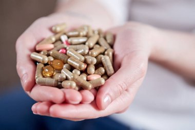 Kadın eli hapları tutuyor, yakın görüş. 