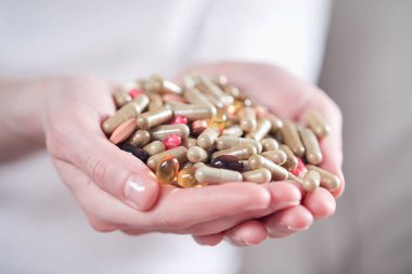 Kadın eli hapları tutuyor, yakın görüş. 