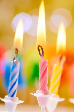 Bulanık arkaplanda renkli doğum günü mumları