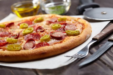 Çatallı lezzetli pizza ve tahta arka planda bıçak.