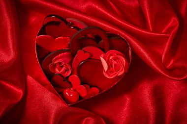Sevgililer günü süsleri kırmızı ipek kumaş üzerine yürekleri 