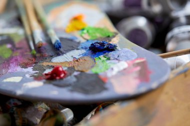 Renkli arkaplanda sanatçı boya fırçaları, yakın plan