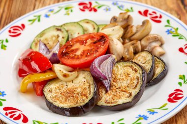 Beyaz tabakta sarımsak ve biberli ızgara sebze, yakın görüş. 