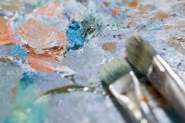 Renkli arkaplanda sanatçı boya fırçaları, yakın plan