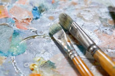 Renkli arkaplanda sanatçı boya fırçaları, yakın plan