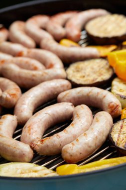 Sosis ve sebzelerden oluşan leziz bir karışım barbeküde ızgara yapıyor. 