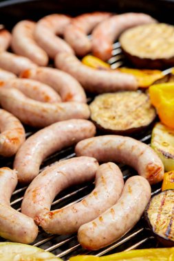 Sosis ve sebze çeşitleri mangalda kızartılıyor. 