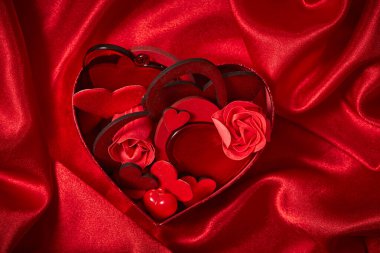 Kırmızı ipek arka planda sevgililer günü için güzel kırmızı süslemeler, yakın plan.  