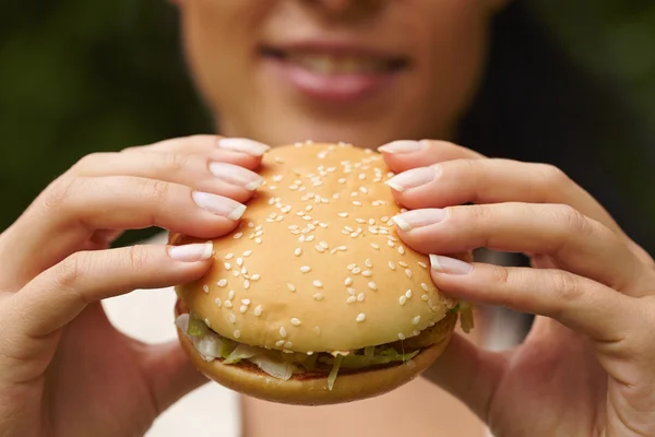 Žena jíst hamburger — Stock fotografie